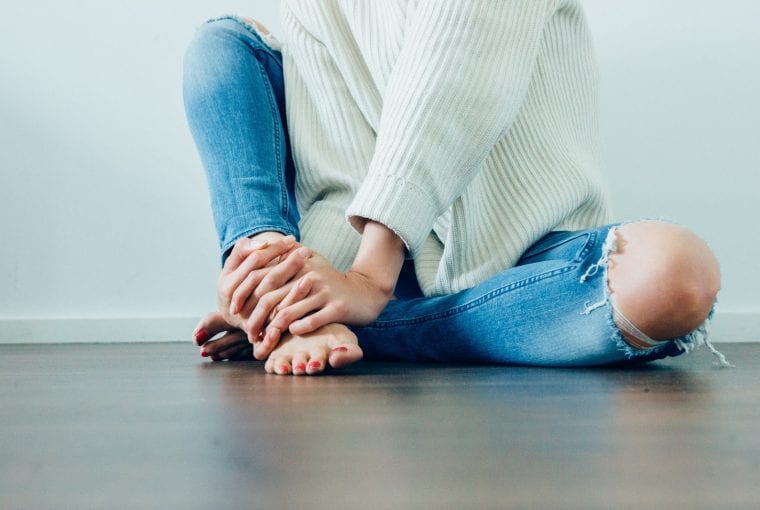 woman sitting barefoot on the floor
