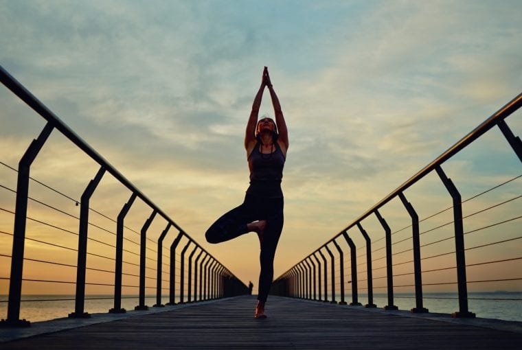 woman doing yoga at sunset