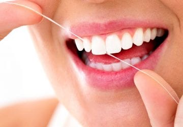 Woman smiling with flossing her teeth