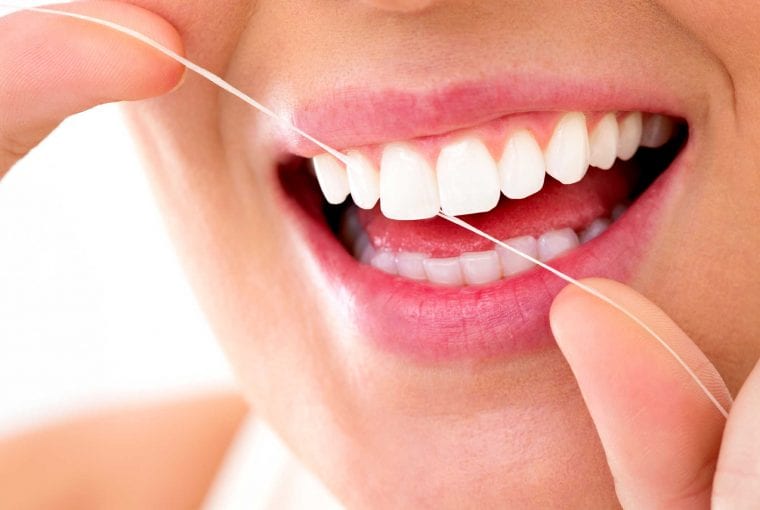 Woman smiling with flossing her teeth