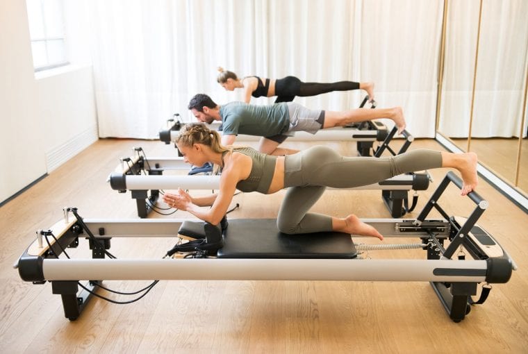 people using a reformer in their pilates class