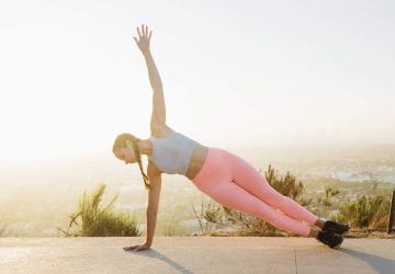woman doing a side plank outdoors
