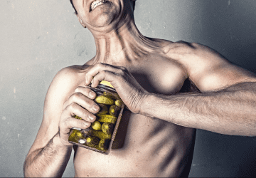 man trying to open a jar of pickles