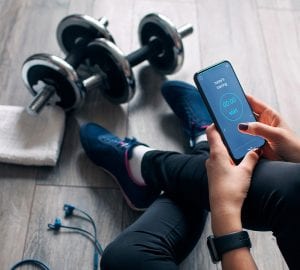 woman sitting on the floor looking at her smartphone