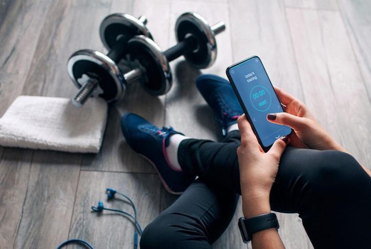 woman sitting on the floor looking at her smartphone
