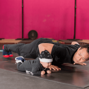 man working out next to his baby