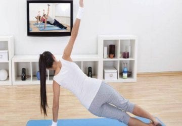 waman exercising in front of a TV