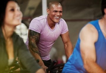a man smiling while ridding in a spin bike class