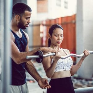 woman getting help by a personal trainer