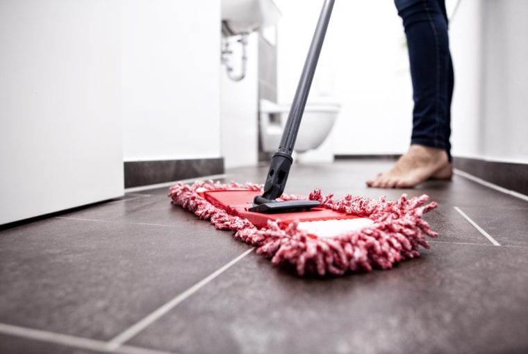 woman cleaning the floor with a mop