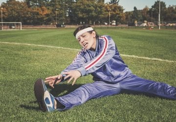 woman stretching in agony on a soccer field