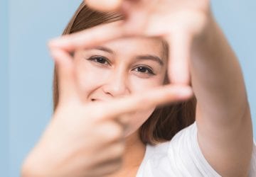 woman posing for a photo with her hands in front of her face