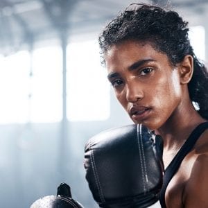 woman boxing in a gym looking into the camera