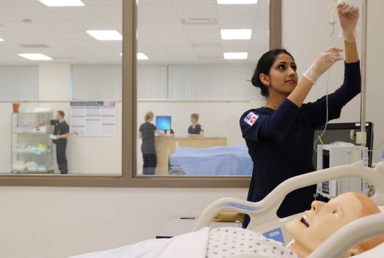 a nursing student hanging an iv