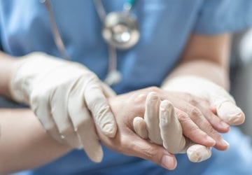 Surgeon, surgical doctor, anesthetist or anesthesiologist holding patient's hand for health care trust and support in professional surgical operation, medical anesthetic safety, healthcare concept