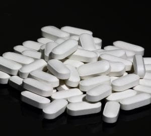 a pile of multivitamins against a black backdrop