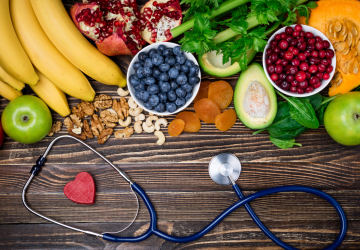 a grouping of healthy foods beside a stethoscope
