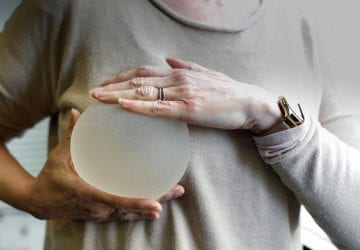 woman holding a breast implant