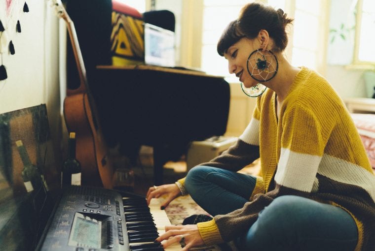 a woman playin gkeyboard in her living room