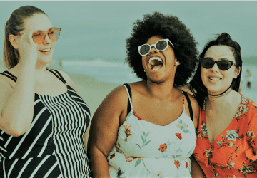 a group of women laughing on the beach