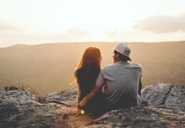 a couple sitting before a beautiful sunrise
