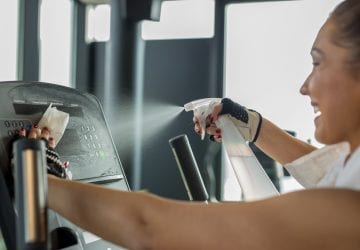 Woman cleaning work out area at the gym