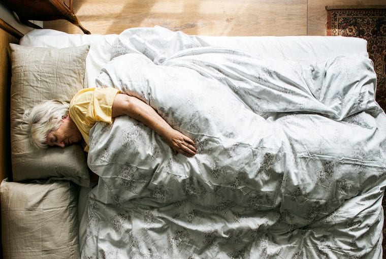 an older woman in her bed sleeping