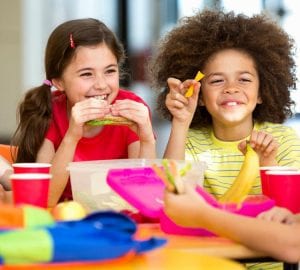 a group of kids eating a healthy meal