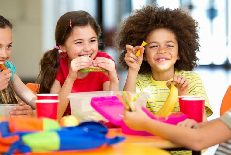a group of kids eating a healthy meal