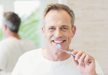 A man brushing his teeth in the bathroom