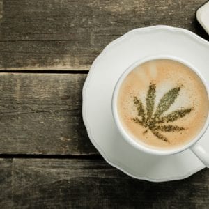 a cup of coffee with a cannabis leaf