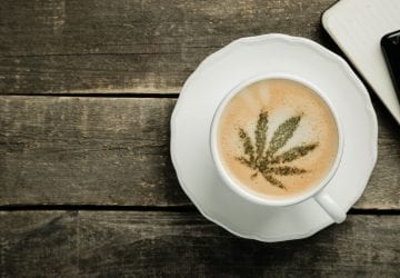 a cup of coffee with a cannabis leaf
