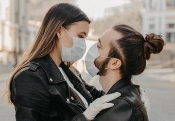 a couple wearing face masks holding each other