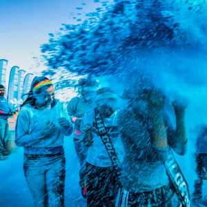 people running in a fun run with blue paint