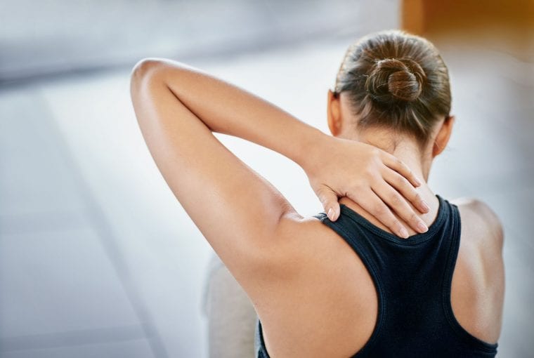 a woman rubbing her sore neck