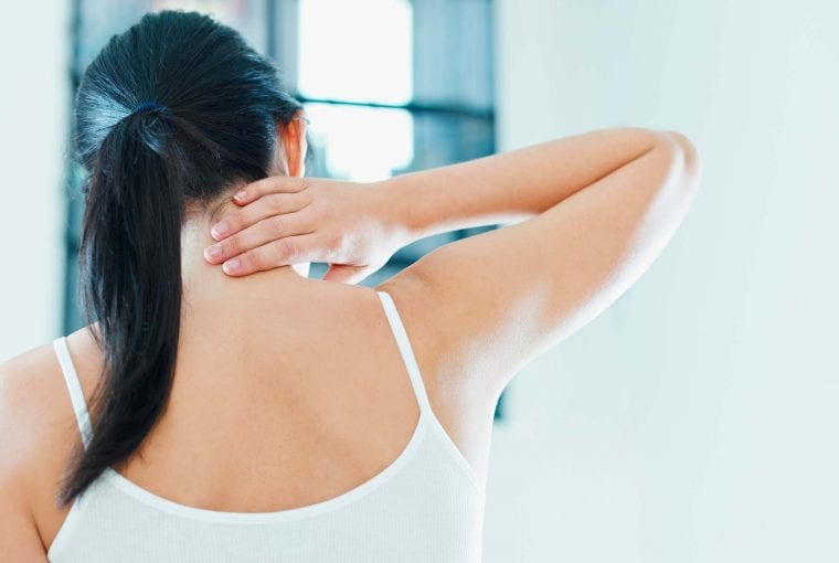 a woman holding her sore neck