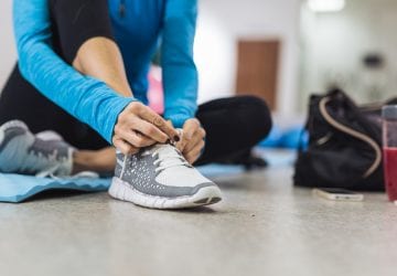 Woman tying shoelace before training in gym