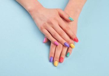 a woman with colourful nails