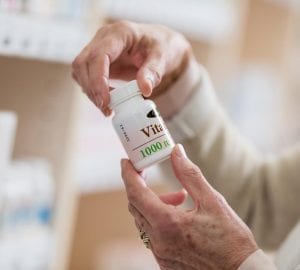 a woman holding a pill bottle