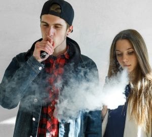 a pair of teens vaping