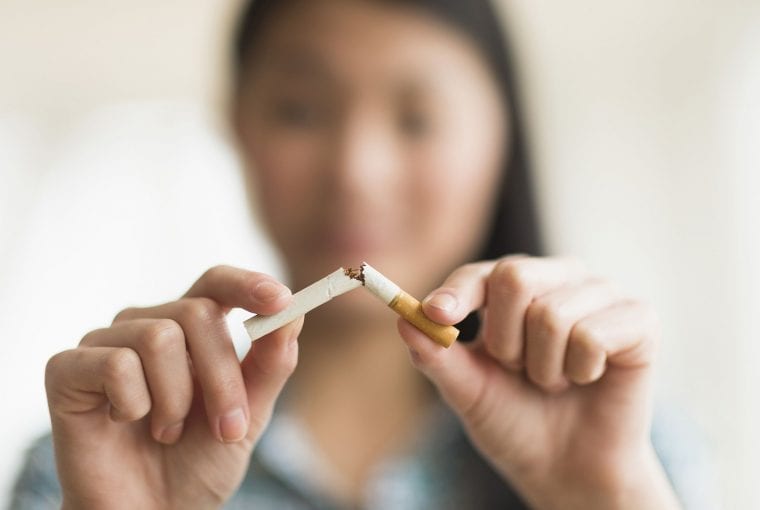 a woman breaking a cigarette