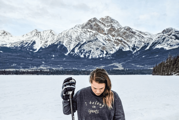 a woman playing hockey outdoors