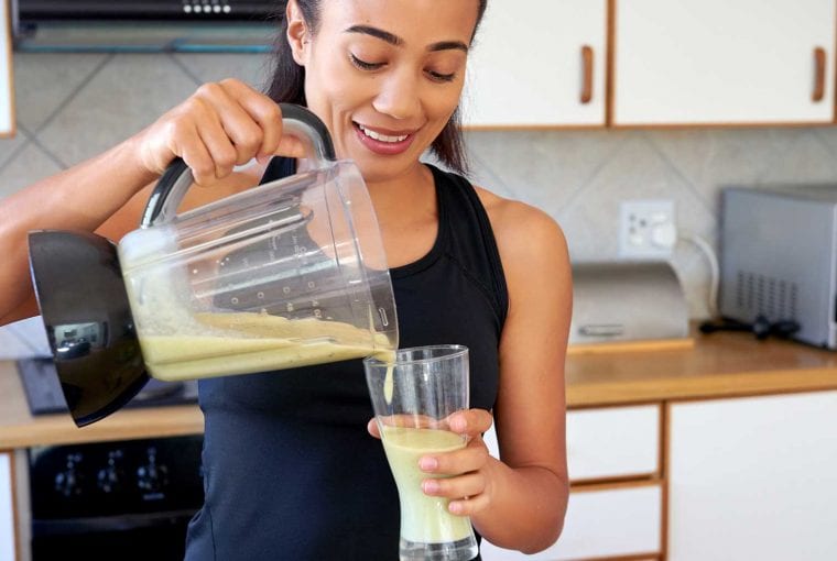 a woman pouring a smoothie