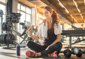 a woman looking at her phone at the gym