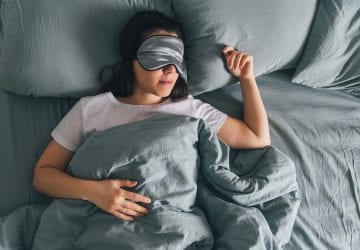 woman sleep in eye patch in grey bed