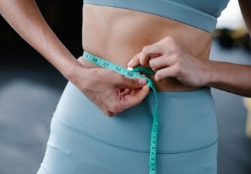 a woman measuring her waist