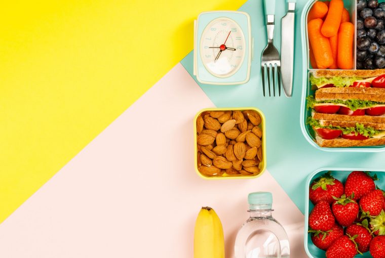 an assortment of foods beside a clock