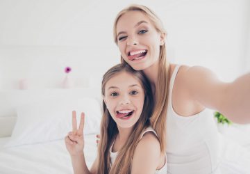 a mom and her daughter smiling