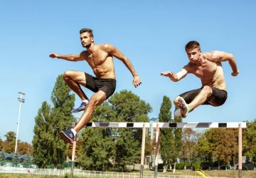 a pair of men doing hurdles