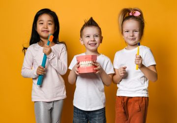 a goup of smiling children holding toothbrushes
